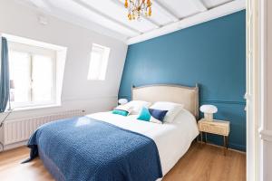 um quarto azul com uma cama com uma parede em tons de azul em Le Lilas - Hypercentre Confort Calme 4 voyageurs em Dijon