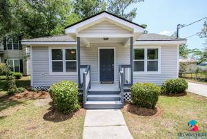 ein kleines weißes Haus mit einer blauen Tür und einer Treppe in der Unterkunft Perchcozy, Quiet Home Close To Sav, I-95 Pets in Savannah