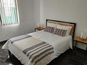 1 dormitorio con 1 cama grande y 2 mesitas de noche en CASA 25, en Conceição