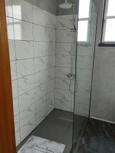 baño con ducha y puerta de cristal en CASA 25, en Conceição