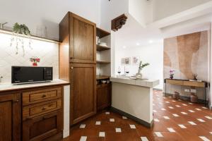 uma cozinha com armários de madeira e uma bancada em Apartments Florence- Faenza Terrace em Florença