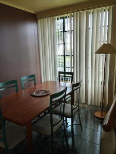 una mesa de comedor y sillas con una gran ventana en CASA 25, en Conceição