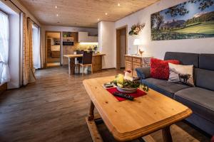 ein Wohnzimmer mit einem Sofa und einem Tisch in der Unterkunft Haus Franz und Haus Antje in Schönau am Königssee