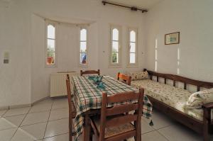 a bedroom with a bed and a table and windows at Villa Aristea in Kalo Chorio +5 photos