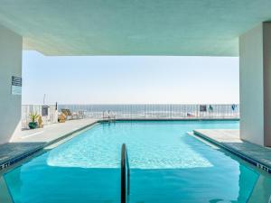 a large blue swimming pool with the ocean in the background at Windemere #1104 in Perdido Key