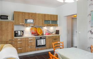 a kitchen with wooden cabinets and a microwave at Cozy Apartment In Wurster Nordseekste With Wifi in Hofe