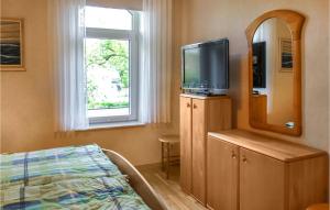a bedroom with a bed and a television on a dresser at Cozy Apartment In Wurster Nordseekste With Wifi in Hofe