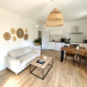 勒拉旺杜的住宿－Le Rossignol 2, Aiguebelle plage Le Lavandou，客厅配有白色的沙发和桌子