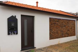 a white building with a door and a parking meter at Dainty House in Ovar