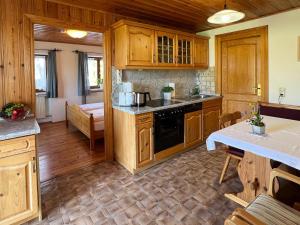 eine Küche mit Holzschränken und einem Herd mit Backofen in der Unterkunft Ferienwohnungen Loisenhof in Gstadt am Chiemsee