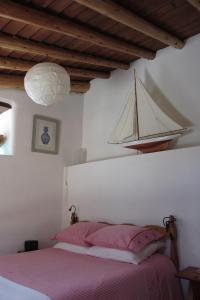 ein Schlafzimmer mit einem Bett mit einem Boot an der Wand in der Unterkunft O Palheiro in Faja Grande