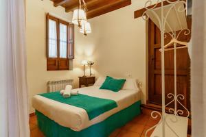 a bedroom with a bed with green and white sheets at Charminghomesgranada Apartamento Fajalauza in Granada