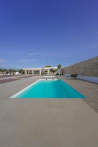 een groot blauw zwembad met een gebouw op de achtergrond bij Moott Homes Suites Villa Costacabana in Almería