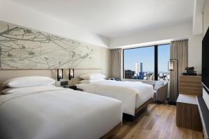 two beds in a hotel room with a large window at Courtyard by Marriott Nagoya in Nagoya