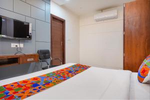 Zimmer mit einem Bett mit einer bunten Decke in der Unterkunft FabHotel Coral in Indore