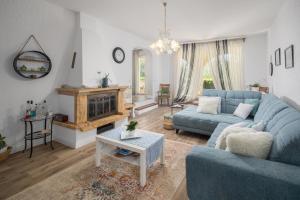 sala de estar con sofá azul y chimenea en Family Vacation Villa, en Žbandaj