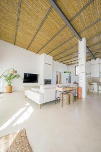 a living room with white furniture and a wooden ceiling at Moott Homes Suites Villa Costacabana in Almería