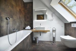 a bathroom with a sink and a tub and a toilet at Rezidence Pihel in Nový Bor