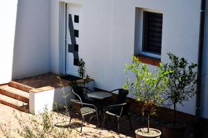 eine Terrasse mit einem Tisch, Stühlen und einem Fenster in der Unterkunft Chilling On Orfű Apartman in Orfű