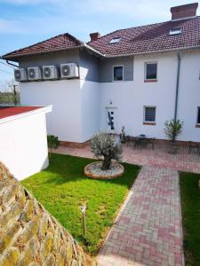 Cette maison blanche dispose d'une terrasse et d'une cour. dans l'établissement Chilling On Orfű Apartman, à Orfű