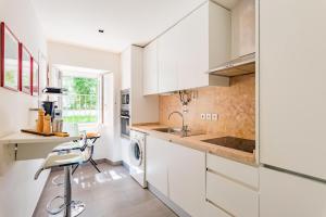 a kitchen with white cabinets and a sink and a dishwasher at Lisbon Prime Apartment in Lisbon