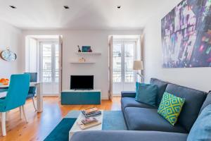 uma sala de estar com um sofá azul e uma mesa em Lisbon Prime Apartment em Lisboa