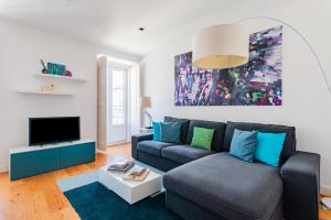 uma sala de estar com um sofá e uma televisão em Lisbon Prime Apartment em Lisboa