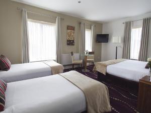 a hotel room with two beds and a table at Arlington Hotel O'Connell Bridge in Dublin