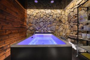 a bath tub in a room with a stone wall at Rezidence Pihel in Nový Bor