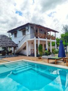 a villa with a swimming pool and a house at Daima Villas in Jambiani