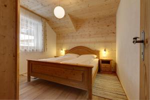 een slaapkamer met een bed in een houten kamer bij Schüsslerhof in Campo Tures