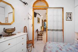- une chambre avec un lit, une commode et un miroir dans l'établissement Via Corradi, à Sanremo