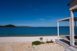 a house on the beach with a view of the ocean at Buqez resort Drage, villa Vita 50 in Pakoštane