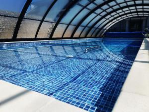 a swimming pool with blue tiles in a building at Holiday Baltic Sun in Sztutowo