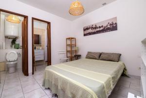 a bedroom with a bed and a bathroom with a toilet at Emplacement idéal au cœur de Sanary sur le port vue mer in Sanary-sur-Mer