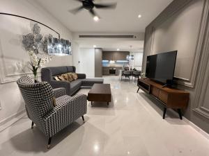 een woonkamer met een bank en een flatscreen-tv bij Eaton Suites KLCC by QC in Kuala Lumpur
