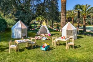 a group of tents with tables and chairs in the grass at La Bobadilla, a Royal Hideaway Hotel in Villanueva de Tapia