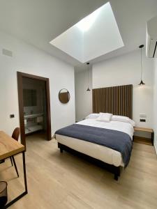 1 dormitorio con 1 cama grande y 1 mesa en Evenia Alcalá Boutique Hotel en Alcalá de Henares