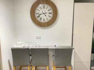 una mesa con sillas y un reloj en la pared en Oxford Studios, en Kidlington