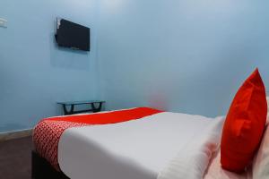 Bhiwāni的住宿－OYO Shree Shyam Roseberry Hotel And Restaurant，一间卧室配有一张带红色枕头的床和一台电视。