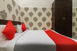 Bhiwāni的住宿－OYO Shree Shyam Roseberry Hotel And Restaurant，一间卧室配有一张带红色枕头的大床