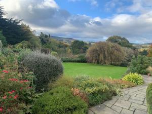 un jardín con césped y algunos arbustos en Self catering apartment at Beechwalk House. en Enniskerry