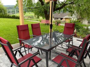 a table and chairs with an umbrella on a patio at Ruhiges Ferienhaus nahe Kurort Bad Gleichenberg. 