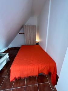 a bedroom with a red bed in a attic at ALYANA in Córdoba