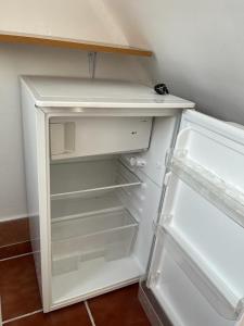 an empty white refrigerator with its door open at ALYANA in Córdoba