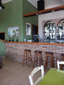 a bar with wooden stools and a brick wall at Soulis Hotel in Arkoudi