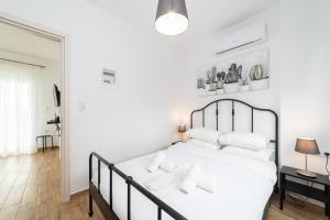 a bedroom with a white bed with white pillows at Danai & Palm Residential Complexes in Ofrínion