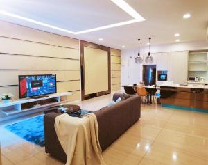 a living room with a couch and a tv and a kitchen at Eve Suite 2 bedrooms At Ara Damansara in Petaling Jaya