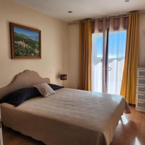 ein Schlafzimmer mit einem großen Bett und einem großen Fenster in der Unterkunft Chambre Shelby avec jacuzzi in Porto-Vecchio