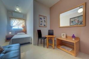 a bedroom with a bed and a desk and a table at Steps from the Sea, Side Sea-View, 3BR Sleep 6 in St. Paul's Bay +8 photos